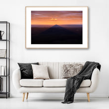 Load image into Gallery viewer, Didthul (Pigeon House Mountain) at sunset with its iconic peak glowing orange above the ocean, casting a dramatic shadow across the coastal landscape in South Coast NSW.