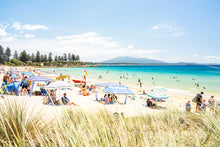 Load image into Gallery viewer, A vibrant beach scene with clear blue skies, featuring people sunbathing, playing, and walking on the beach with the ocean in the background.
Sunny beach landscape with turquoise ocean, golden sand, beach umbrellas, and people enjoying a relaxing summer day.
Bermagui Far south coast Greg Selby photography Horseshoe bay NSW