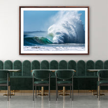 Load image into Gallery viewer, Framed photograph of a large wave in a modern interior setting with green chairs and a white wall.Greg Selby Sapphire coast