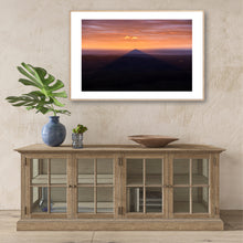 Load image into Gallery viewer, Didthul (Pigeon House Mountain) at sunset with its iconic peak glowing orange above the ocean, casting a dramatic shadow across the coastal landscape in South Coast NSW.
