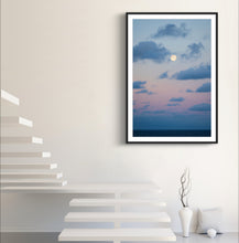 Load image into Gallery viewer, Framed artwork of a sunset over water with a moon, displayed on a wall above a staircase.